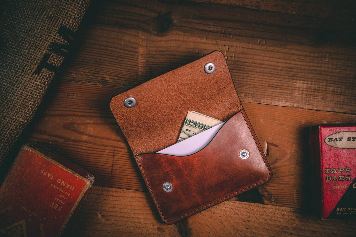 Slim card wallet in buck brown harness leather with solid brass snap