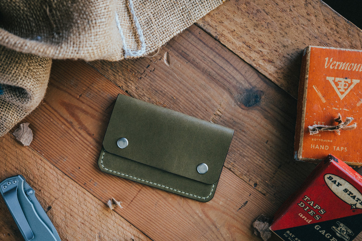 Slim card wallet in olive harness leather with solid brass snap
