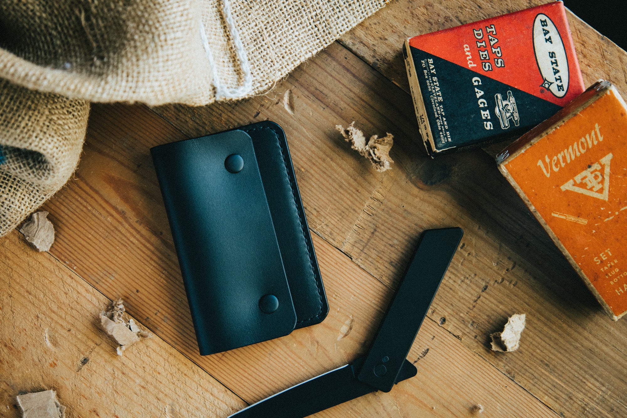 Slim card wallet in black harness leather with solid brass snap