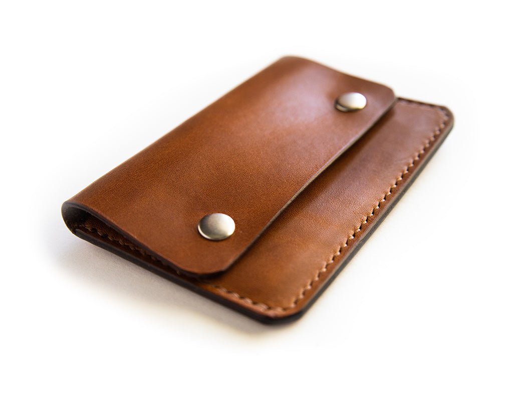 Slim card wallet in buck brown harness leather with solid brass snap
