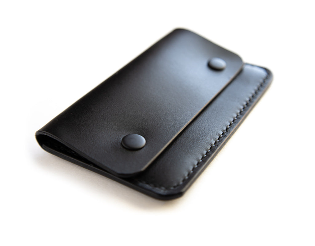 Slim card wallet in black harness leather with solid brass snap
